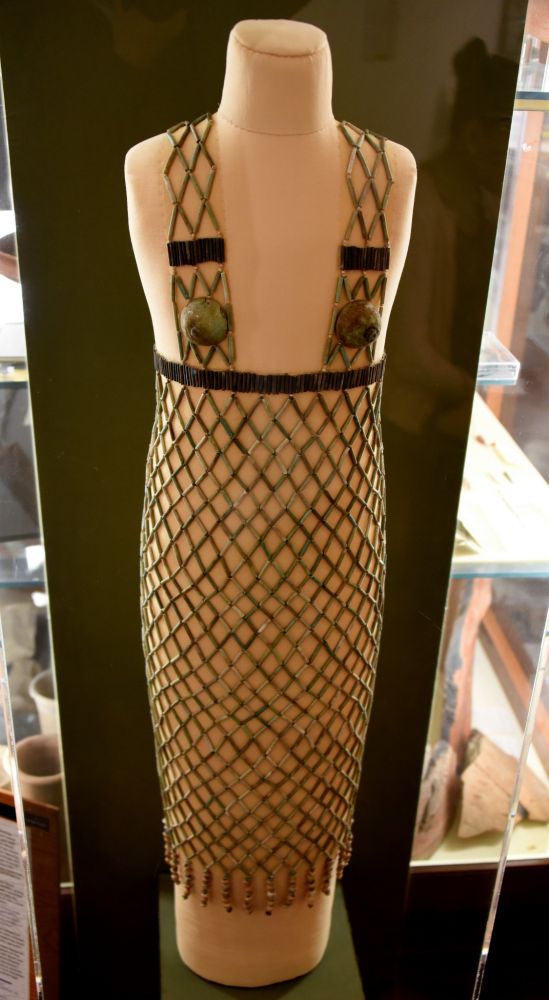 a delicate dress consisting almost entirely of beaded netting. it fits the figure closely. the main body of the dress stops below the bust, and only two straps continue upwards to cover the chest. 

From Wikimedia:
Network dress. Faience, blue and black cylinder beads, 2 breast caps and 2 strings of Mitra beads. 5th Dynasty. From burial 978 at Qau (Tjebu), Egypt. The Petrie Museum of Egyptian Archaeology, London. With thanks to the Petrie Museum of Egyptian Archaeology, UCL.