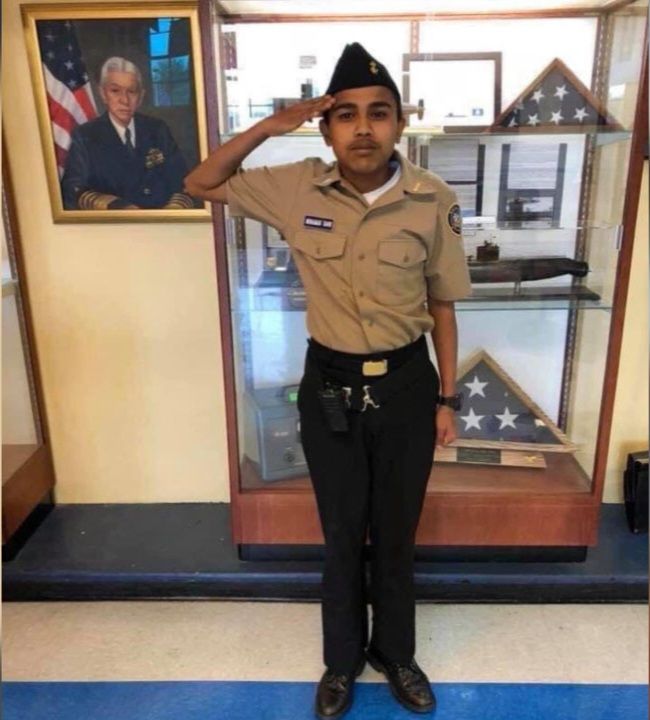 The Hispanic man from the "when x tell me to do something" or "si patrona" meme. He's wearing a navy JROTC uniform and is saluting for the camera