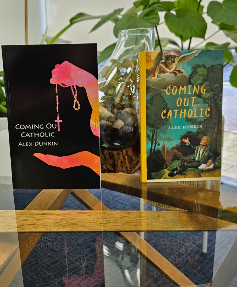 Two different paperback editioms of the young adult novel Coming Out Catholic sit on a glass coffee table. 