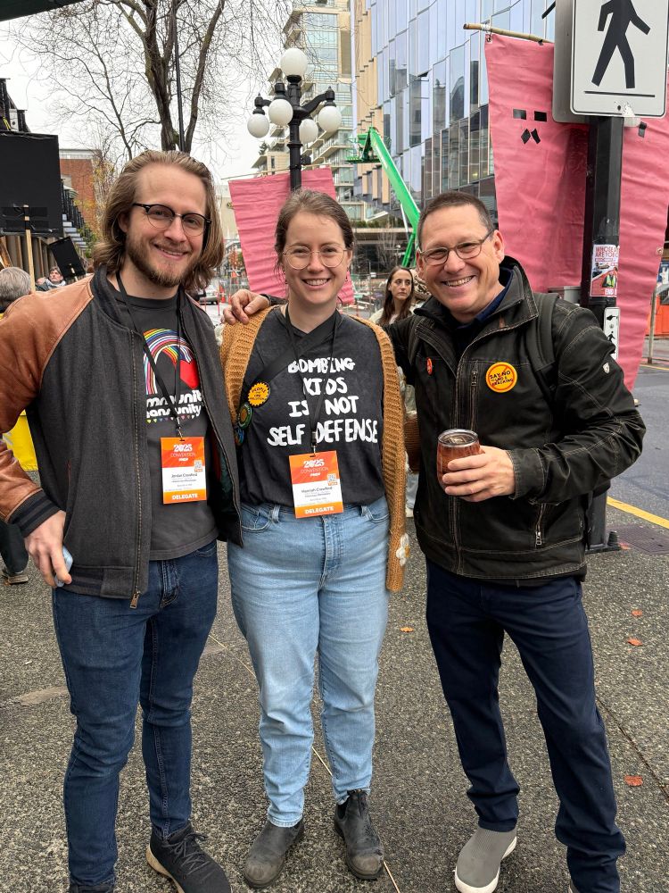 Avi Lewis smiling for a photo with two BC NDP delegates outside the convention.