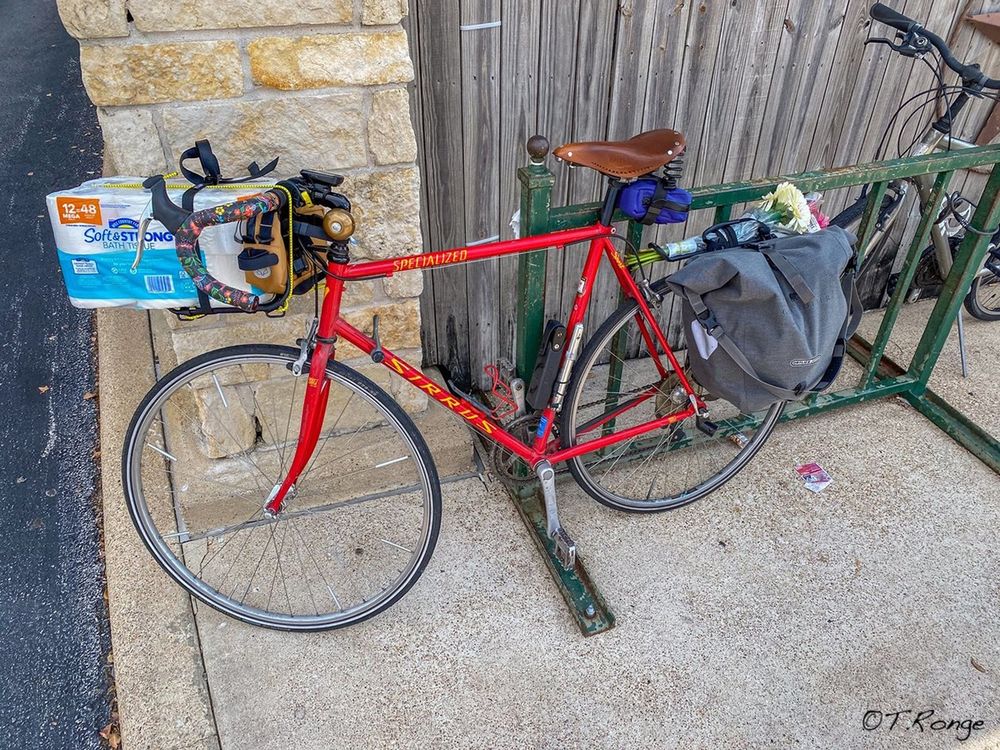 A red bicycle carrying groceries.