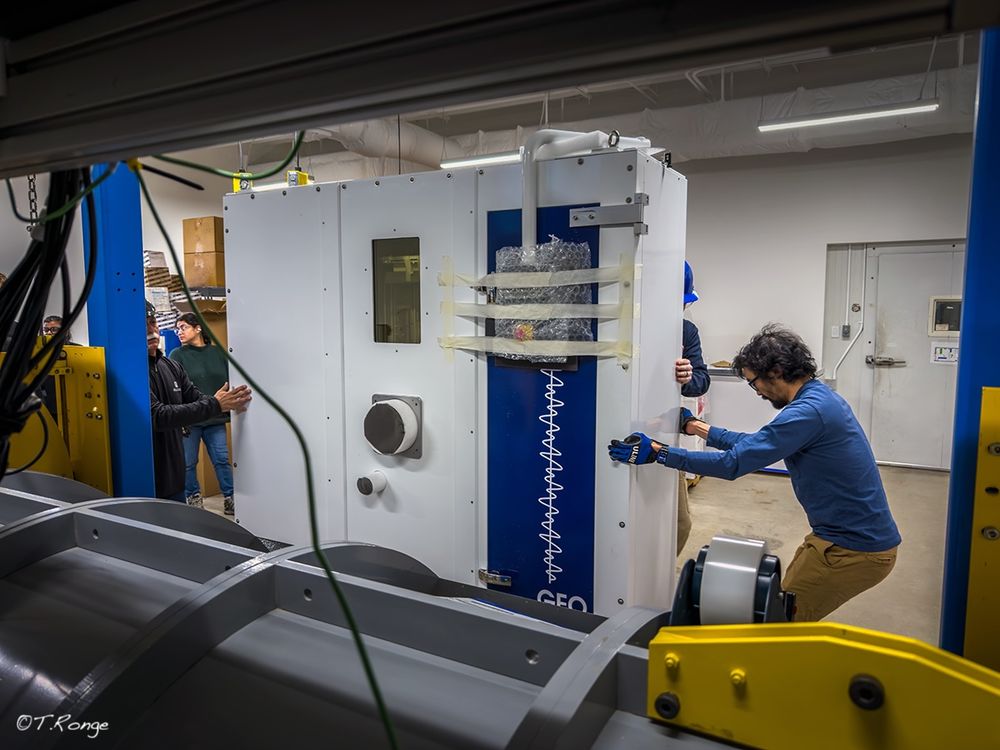 Technicians move the core part of a CT scanner in a lab. 
