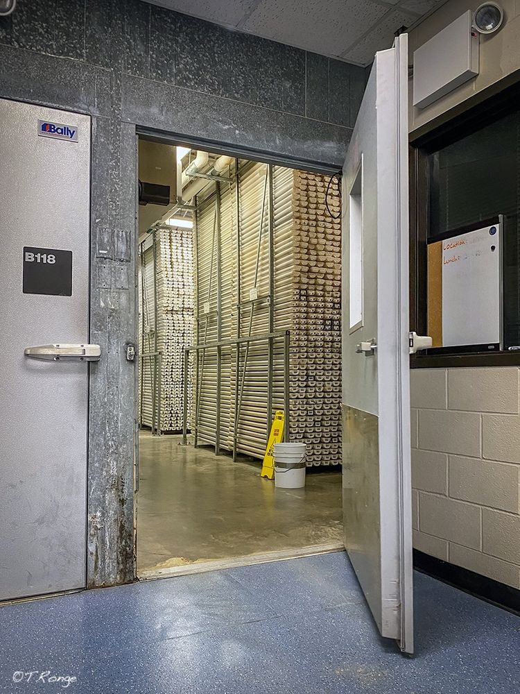An open door leading to the reefer of the Gulf Coast Repository with core sections stacked in shelves.