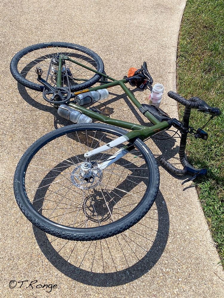 A bicycle destroyed on the ground after being rolled over by a pick-up truck.