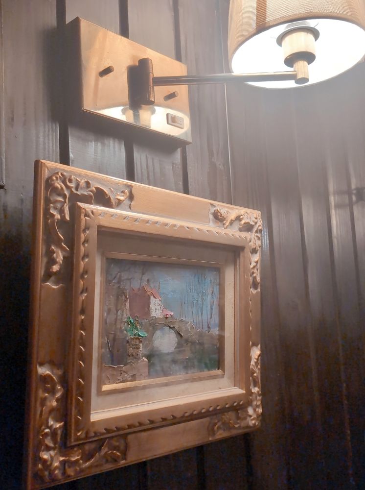 西原珈琲店の店内の壁。木の壁に額装された油彩画が飾られている。