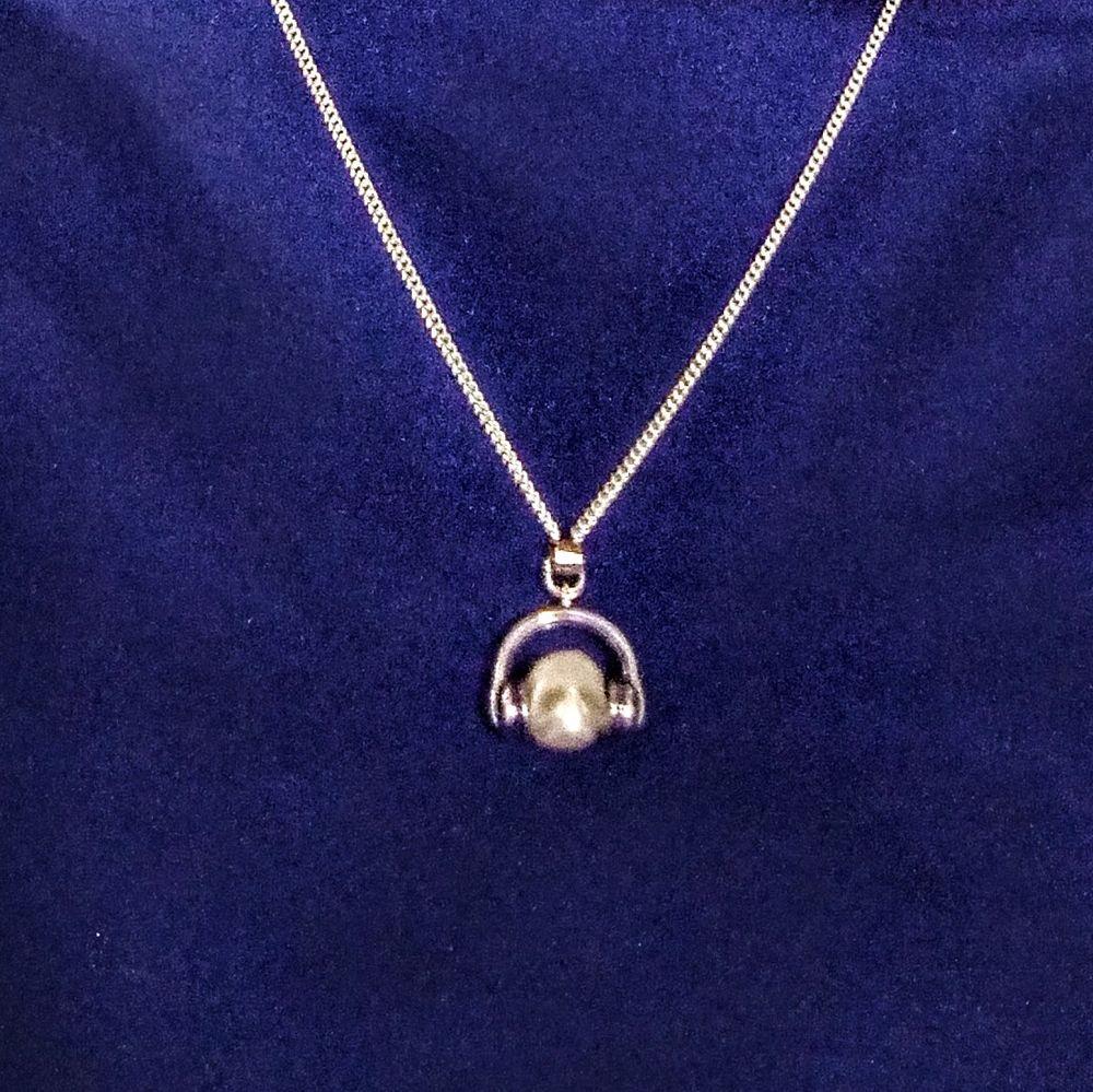 Close up of pendant - skull wearing headphones 