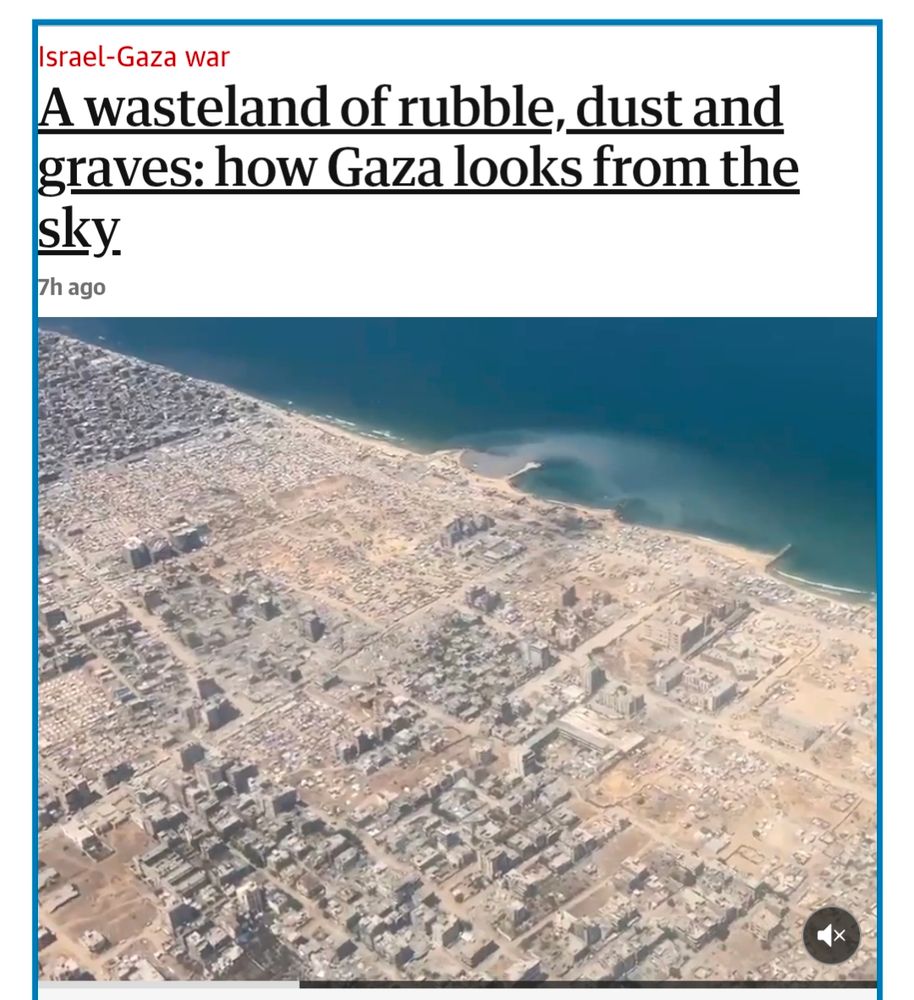 A screenshot from a The Guardian article with the title and subtitle:
"Israel-Gaza war
A wasteland of rubble, dust and graves: how Gaza looks from the sky."
There is a large still from a video, which shows a city on a coastline from the air. Every building has been bombed to rubble, and nothing is left standing.