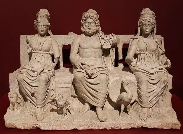 Roman sculpture showing Juno, Jupiter and Minerva seated together on a couch.