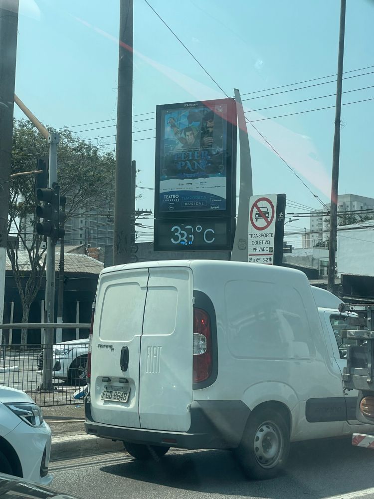 Relógio de rua mostrando a temperatura, mas o painel está com defeito e não dá pra ler o número exato