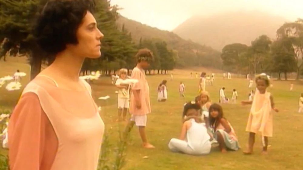 Cristiane Torloni caminha pelos vales verdejantes do além, repleto de crianças vestidas em tons pastéis