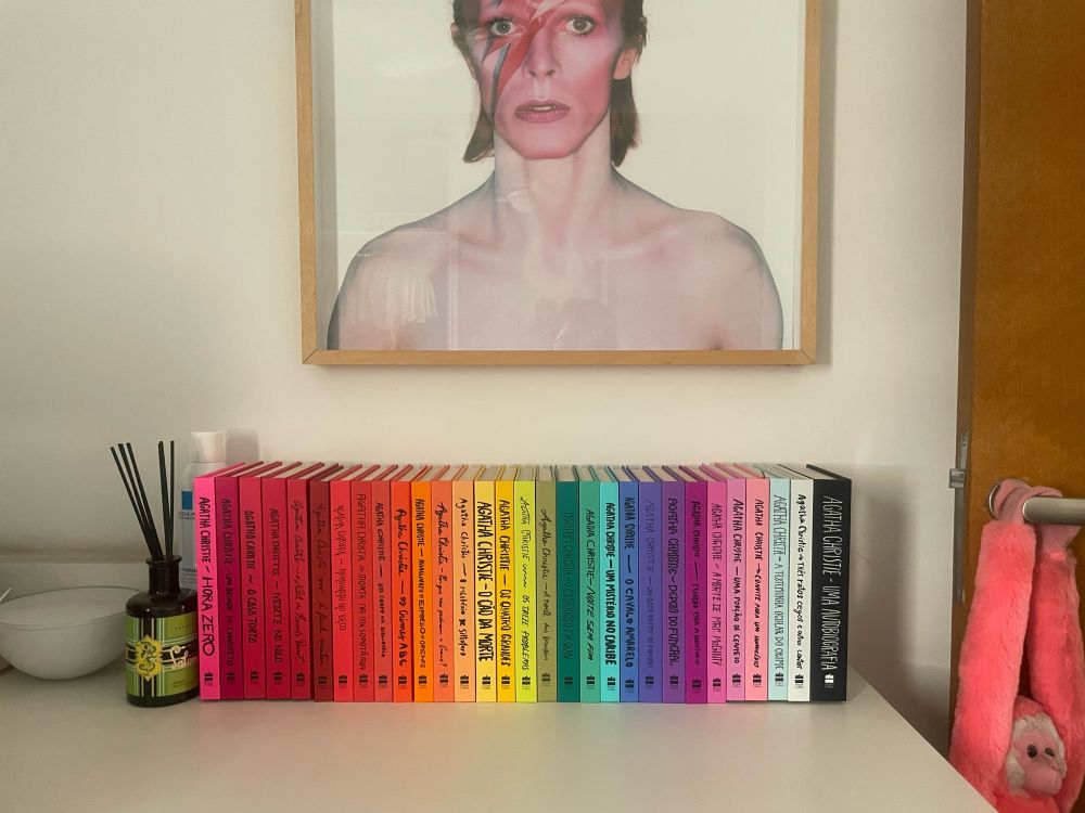 Coleção colorida de Agatha Christie com um quadro do David Bowie na parede