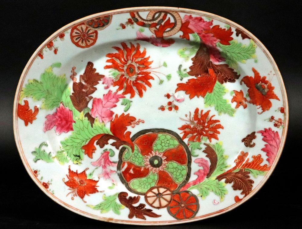 Oval white dish painted with a profusion of red flowers and green leaves 