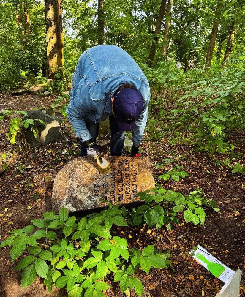 A Jewish man cleaning a headstone