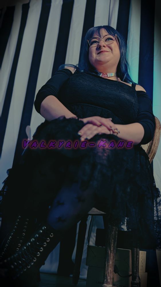 Celleste is sitting pretty in an antique chair, looking like a cutsie goth princess