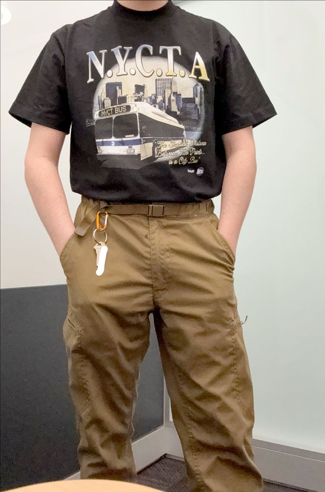 photo from the neck down of myself wearing a shirt with N.Y.C.T.A. "The Shortest Distance Between Two Points Is A City Bus" shirt and khaki cargo pants.