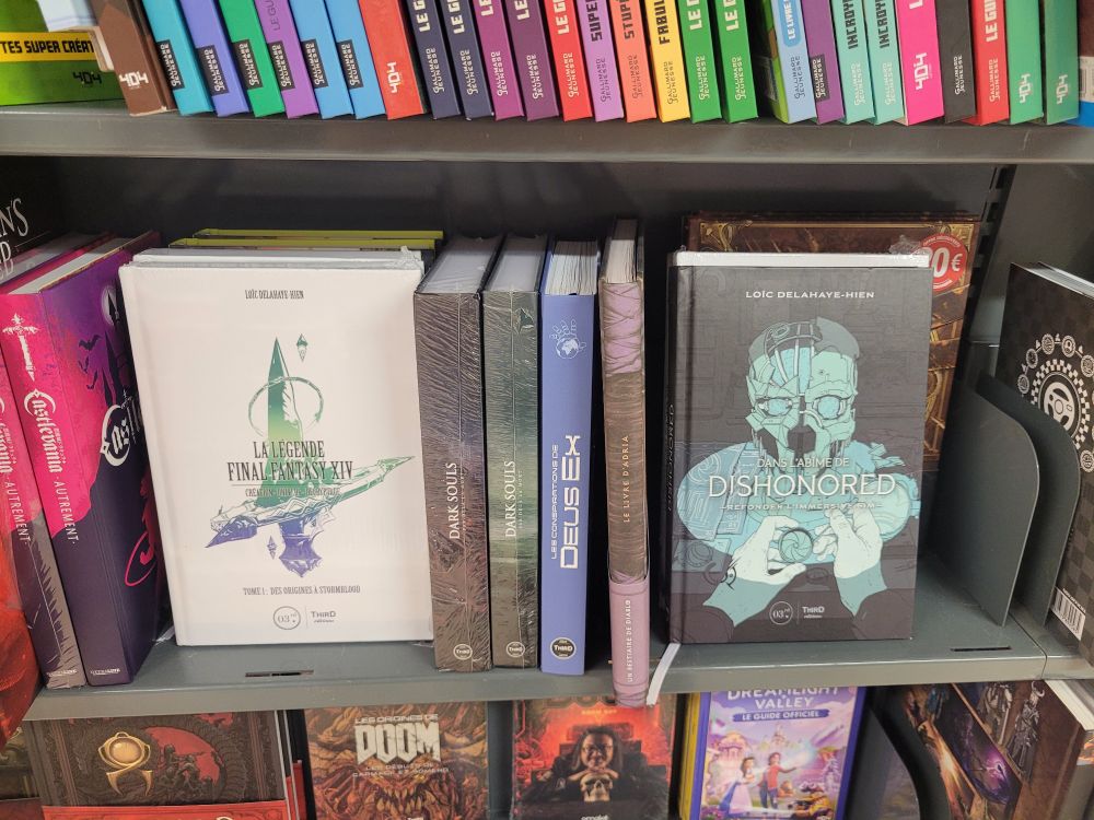 Un rayon de librairie, avec les livres dédiés à FFXIV et Dishonored côte à côte (et écrits par moi-même)