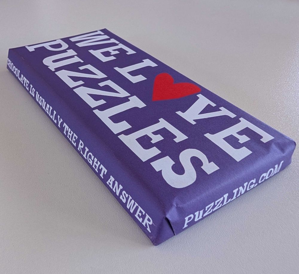 A chocolate bar in a purple wrapper emblazoned with "WE LOVE PUZZLES", "Chocolate is usually the right answer", and "puzzling.com"