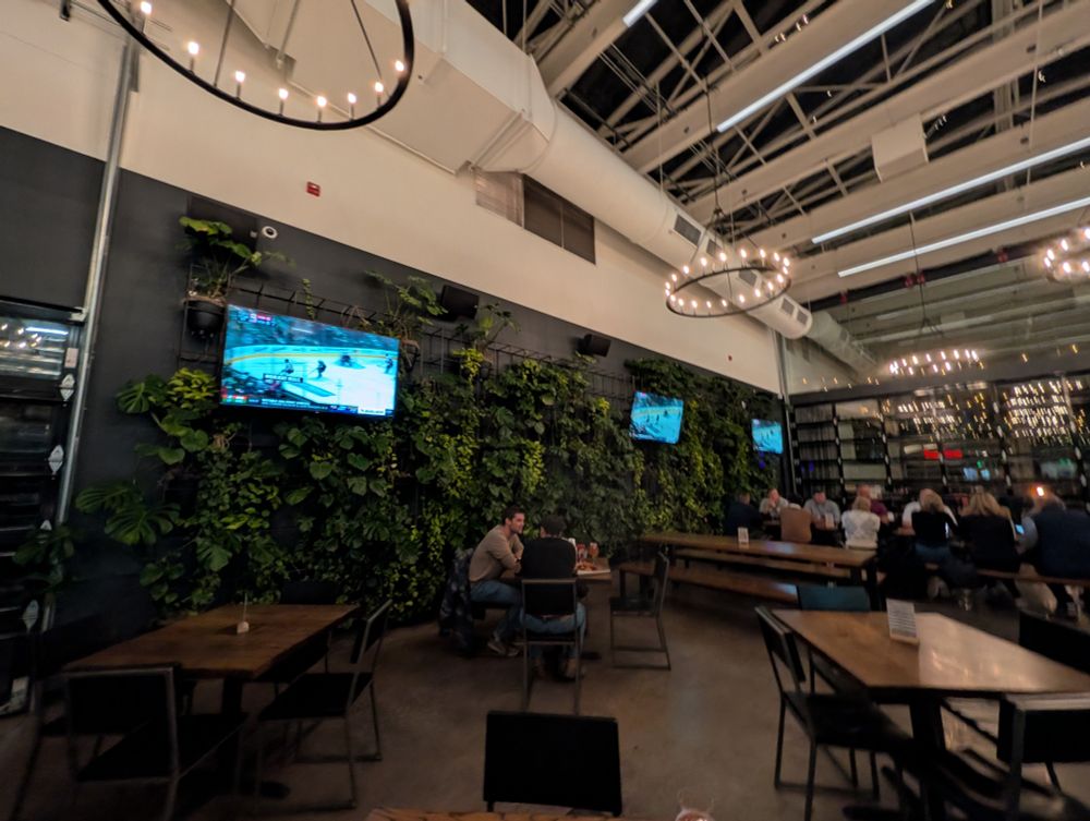 Phot of a brewery with three tvs on the wall all tuned to the Rivalry Series