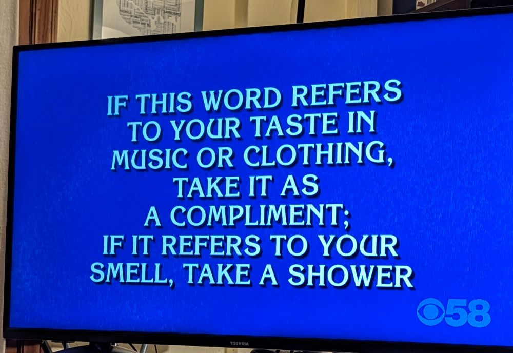 Picture of a blue screen with the Jeopardy clue "If this word refers to your taste in music or clothing, take it as a compliment; if it refers to your smell, take a shower"