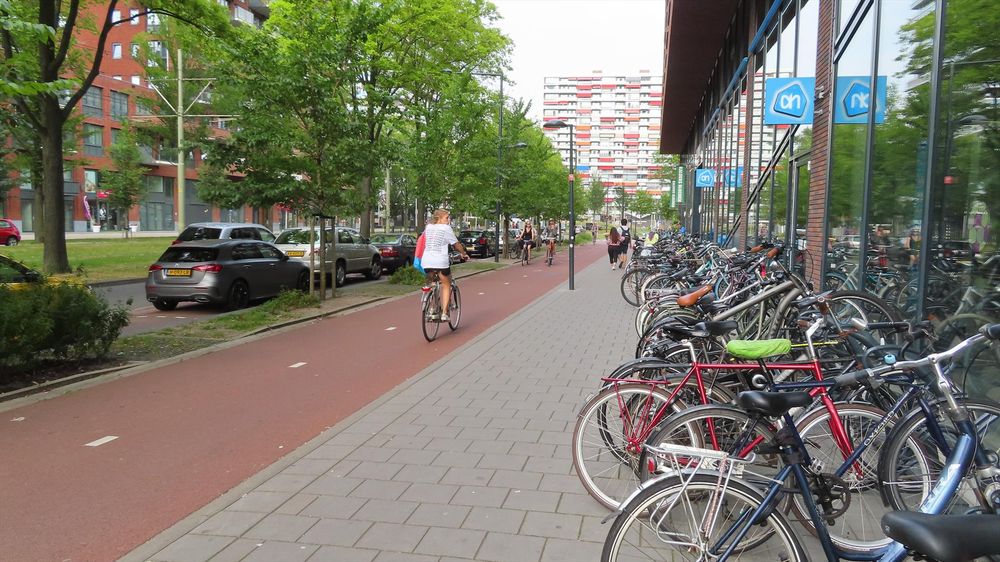 Parked bikes and bike stands outside an Albert Heijn Supermarket in the Netherlands 