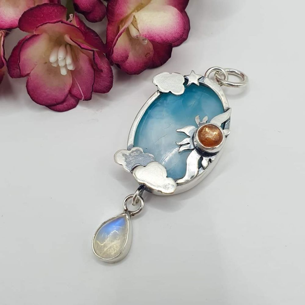 Silver larimar pendant with silver clouds a sunstone and silver sun and moonstone droplet.