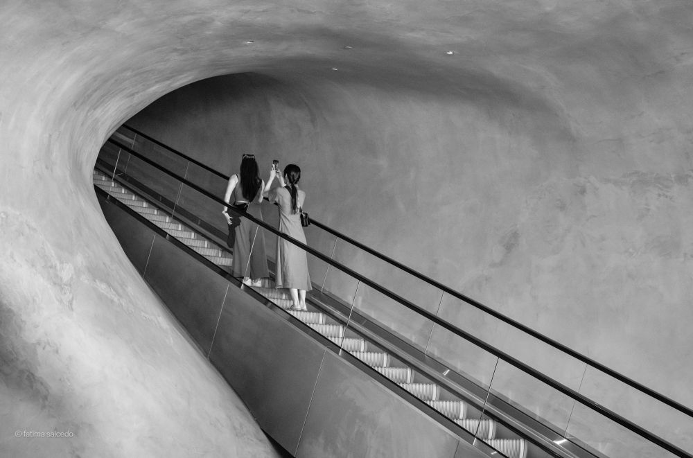 Two girls on the rolling stairs taking photos
