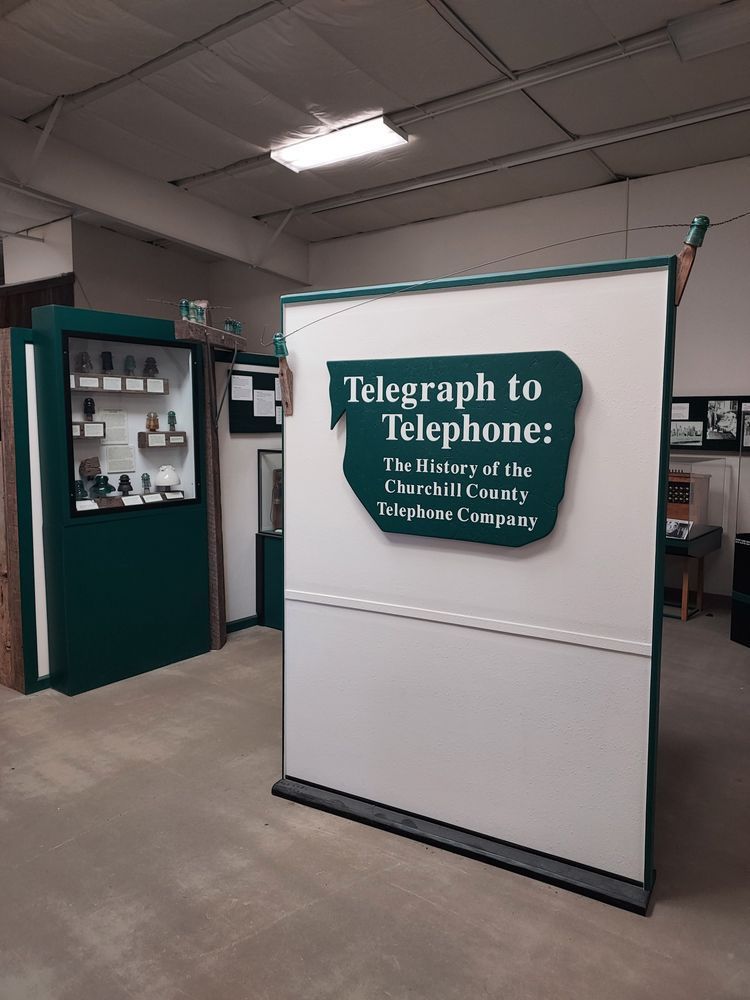 A photo of the exhibit, featuring telephones and glass insulators