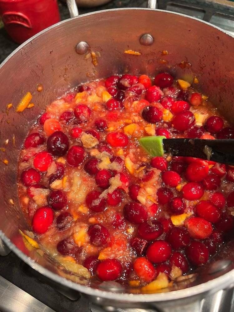 The cranberries, orange, apricot jam and crushed pineapple are incorporated in a saucepan.