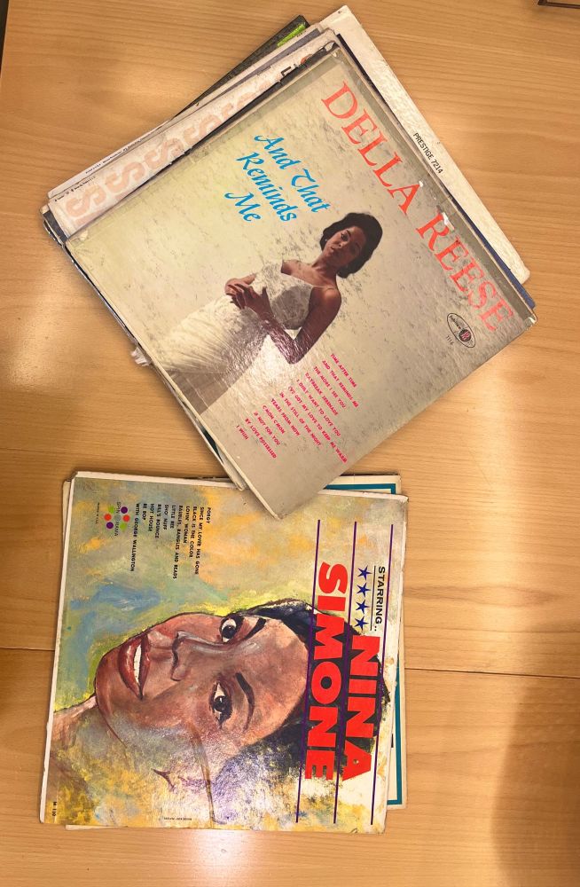 Two stacks of old jazz vinyl records. On the top of the stacks are a Della Reese record and a Nina Simone record