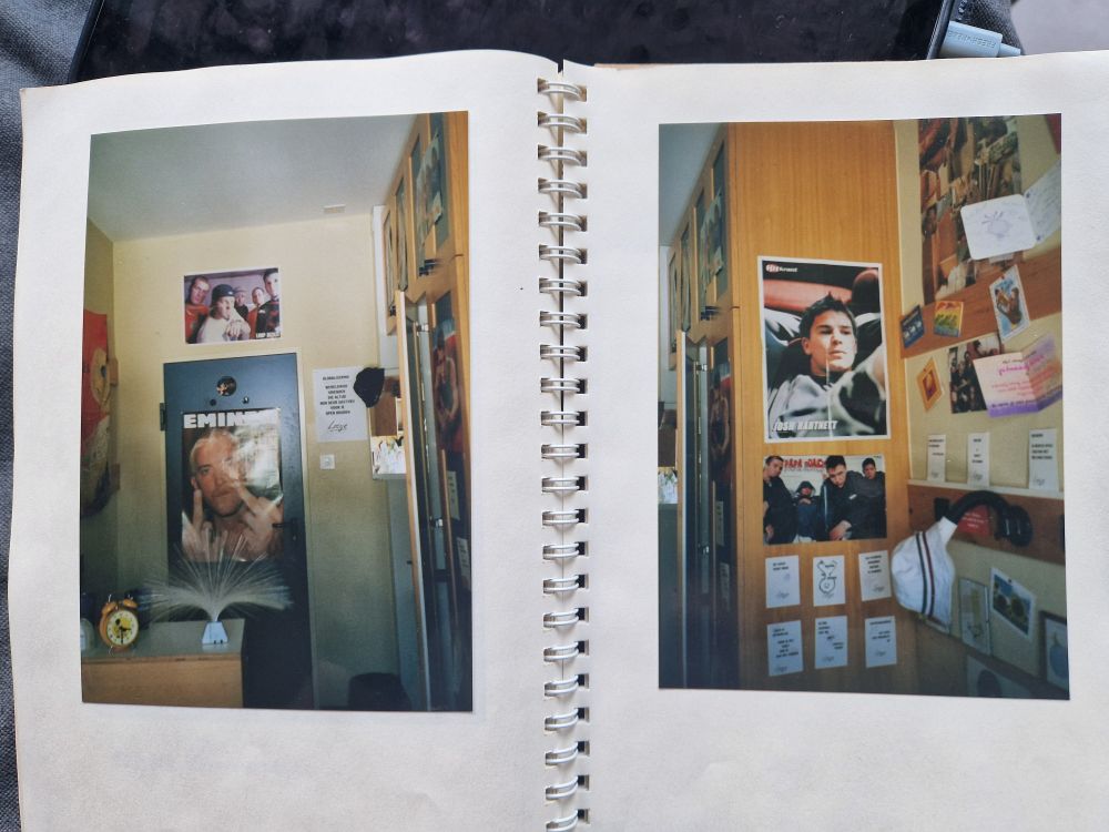 Twee bladzijdes uit een boekje, met foto's van stukjes slaapkamer met posters van Eminem, Limburg Bizkit, Papa Roach, Josh Hartnett en Loesje, een gele hema wekker met Jip en Janneke, zo'n rare sprietjeslamp, een vlag van Korn, véél ansichtkaarten van Loesje, een vissershoedje (R U kiddin' me #iykyk)
