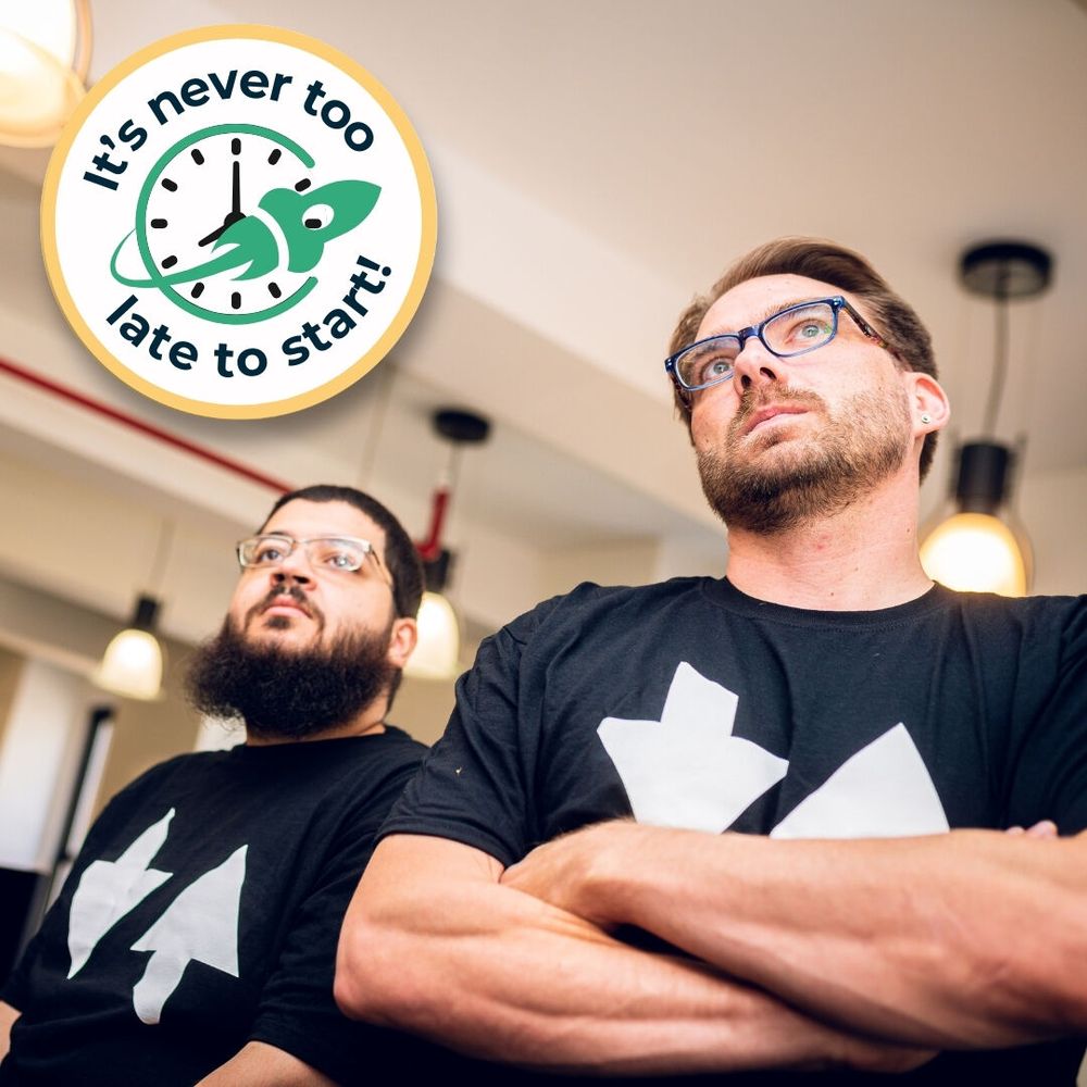 Two male Zip Coders, standing confidently in a classroom. Graphic reads, "It's never too late to start!"