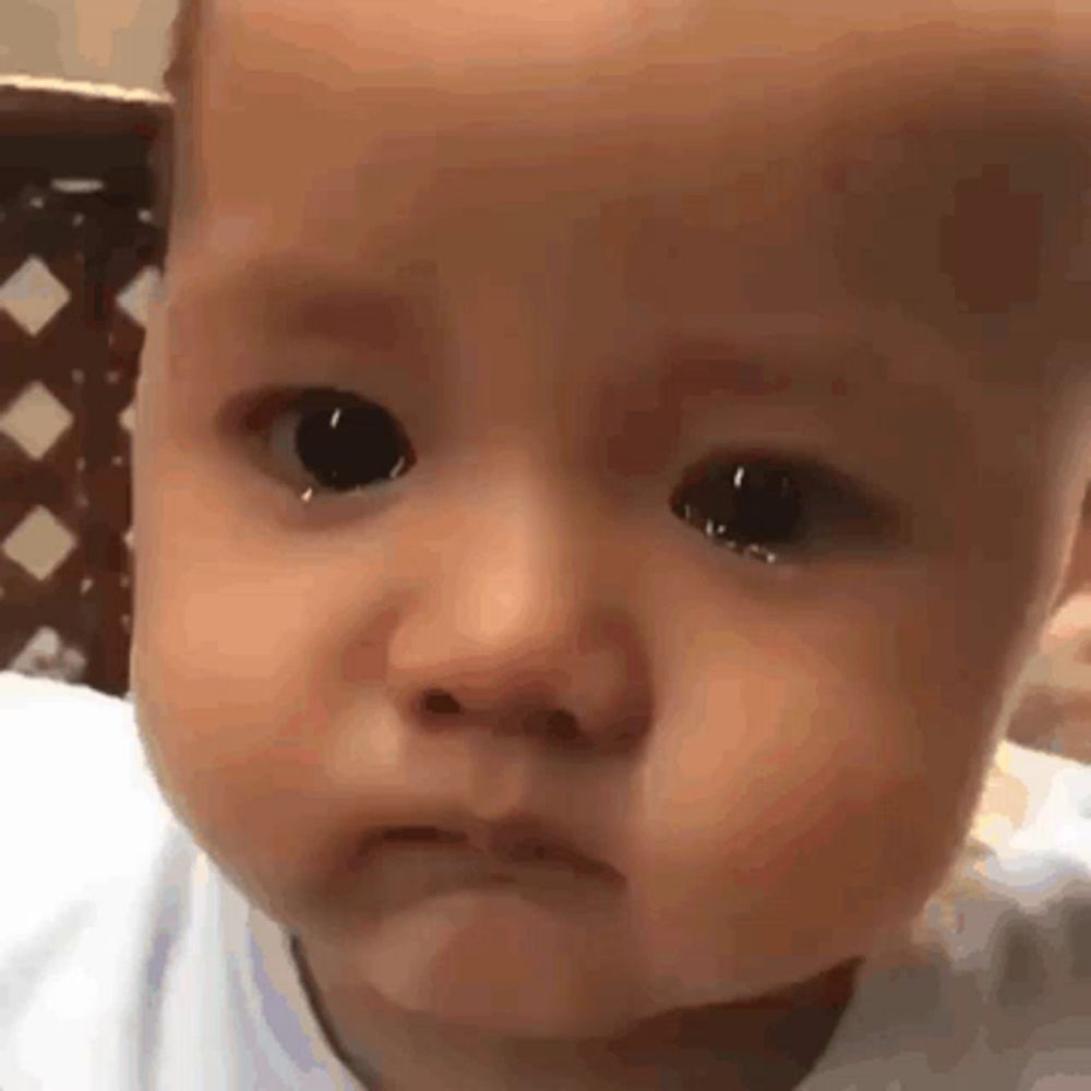 a baby is crying with tears running down his face .