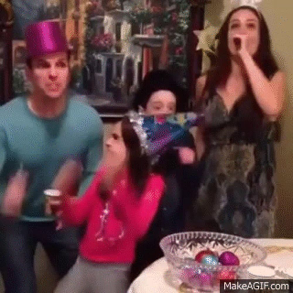 a family wearing party hats is dancing at a party .