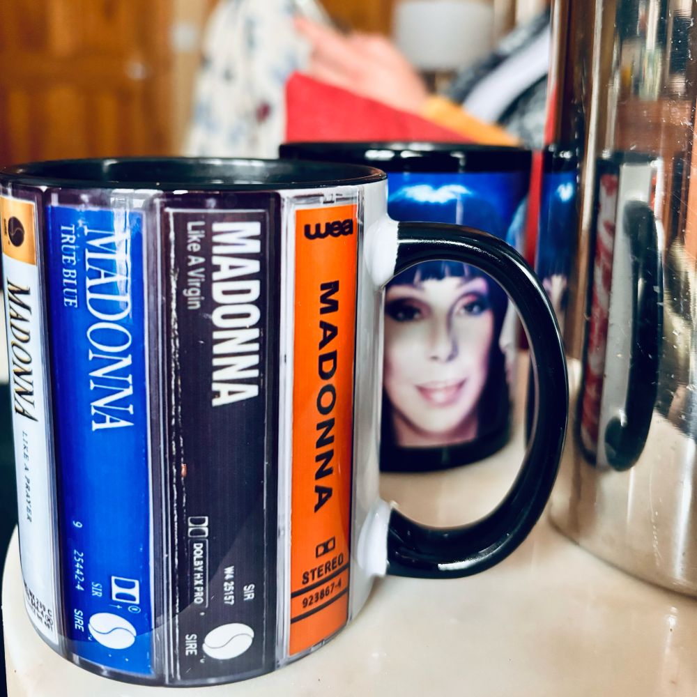 Dueling coffee mugs featuring Madonna and Cher surround a carafe