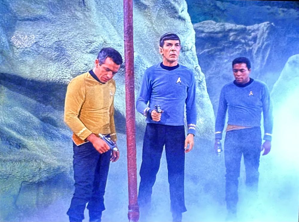 Scene from Star Trek (the original series) episode “The Galileo Seven”, showing Mr. Spock and two rando crewmen discovering a gigantic spear thrown by a very large alien hominid. 