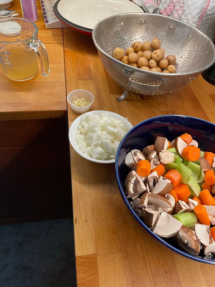 Prepared garlic, onions, carrots, celery, mushrooms, and potatoes to add to the pot