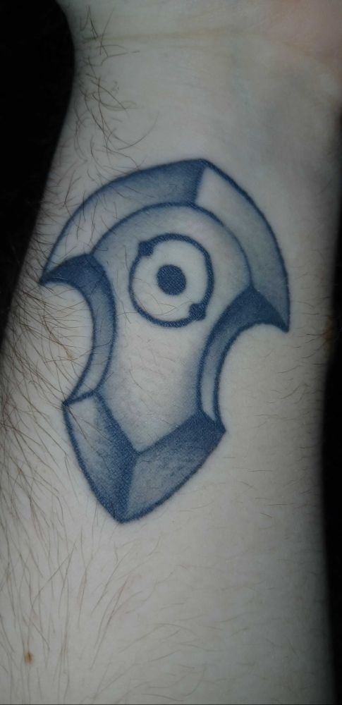 a tattoo with the alchemical symbol of the sun 