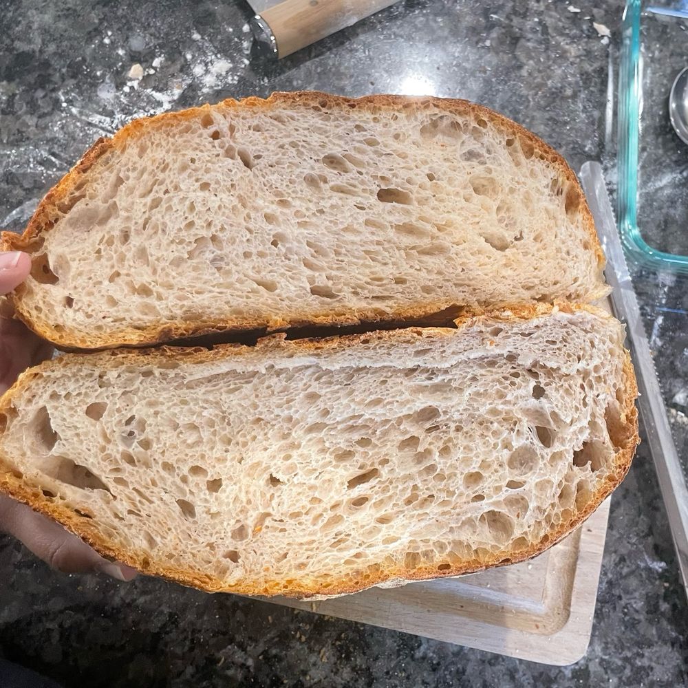Sourdough loaf cut in half to show the crumb or air pocket distribution.