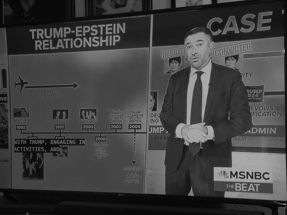 TL of Trumps connections to Epstein drawn out on billboard behind a standing Ari Melber LEFT SIDE IF BOARD — HEADER READS —TRUMP-EPSTEIN RELATIONSHIP Timeline shows The New York Times 7 PRIVATE JET TRIPS MAR A-LAGO PARTY 1992 MAR A LAGO 1997 MAR A-LAGO 2000 NEW YORK logo TRUMP:EPSTEIN A 