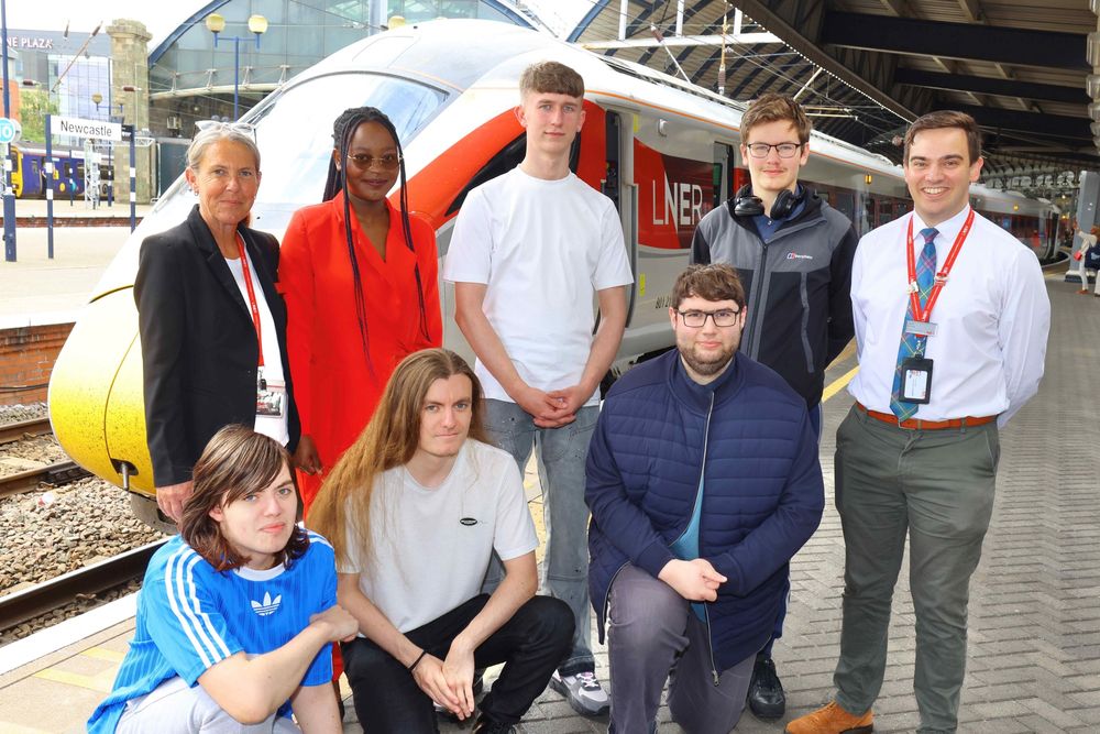 The six young people with two LNER colleagues standing in front of an Azuma train