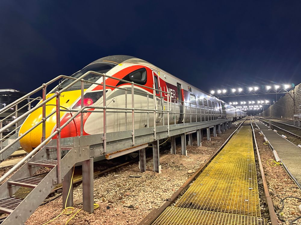 Azuma 800111 stands on Road 3 at Clayhills depot with an elevated steel walkway in front of the train and yellow walkway between the rails on Road 2 on the bottom right of the picture