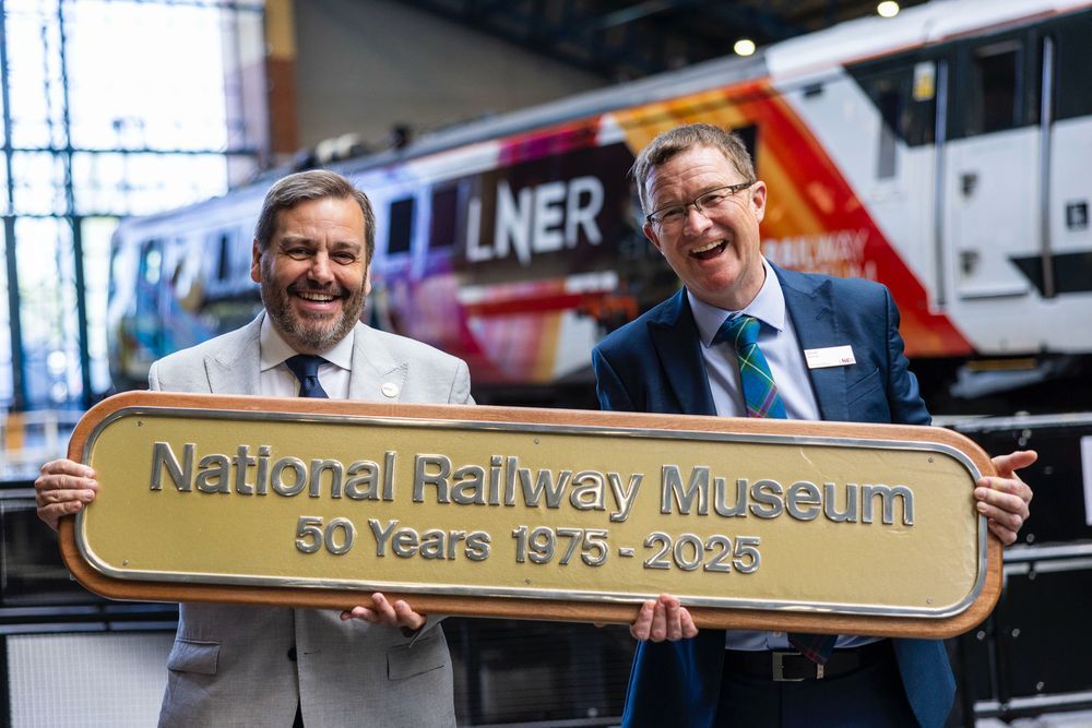 David Horne presenting a replica nameplate to Andrew McClean, Head Curator, the nameplate reads National Railway Museum 50 Years 1975-2025