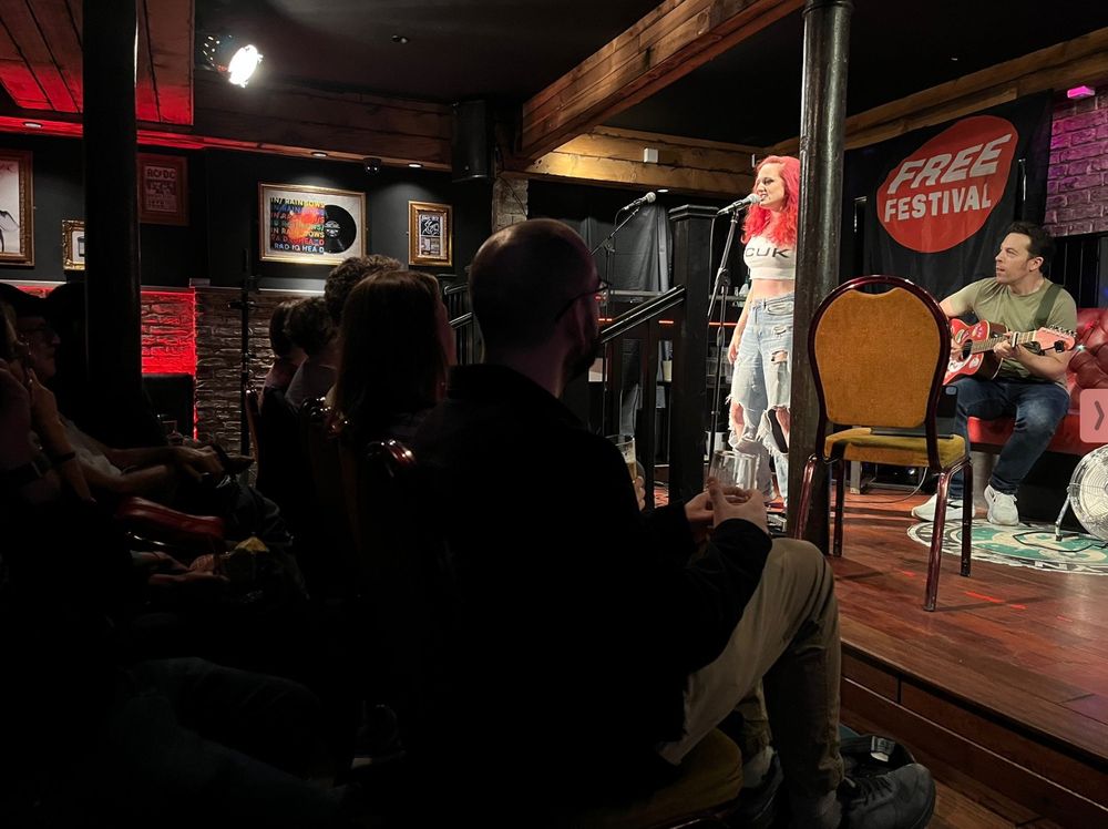 Michael on guitar, me on mic, audience on chairs