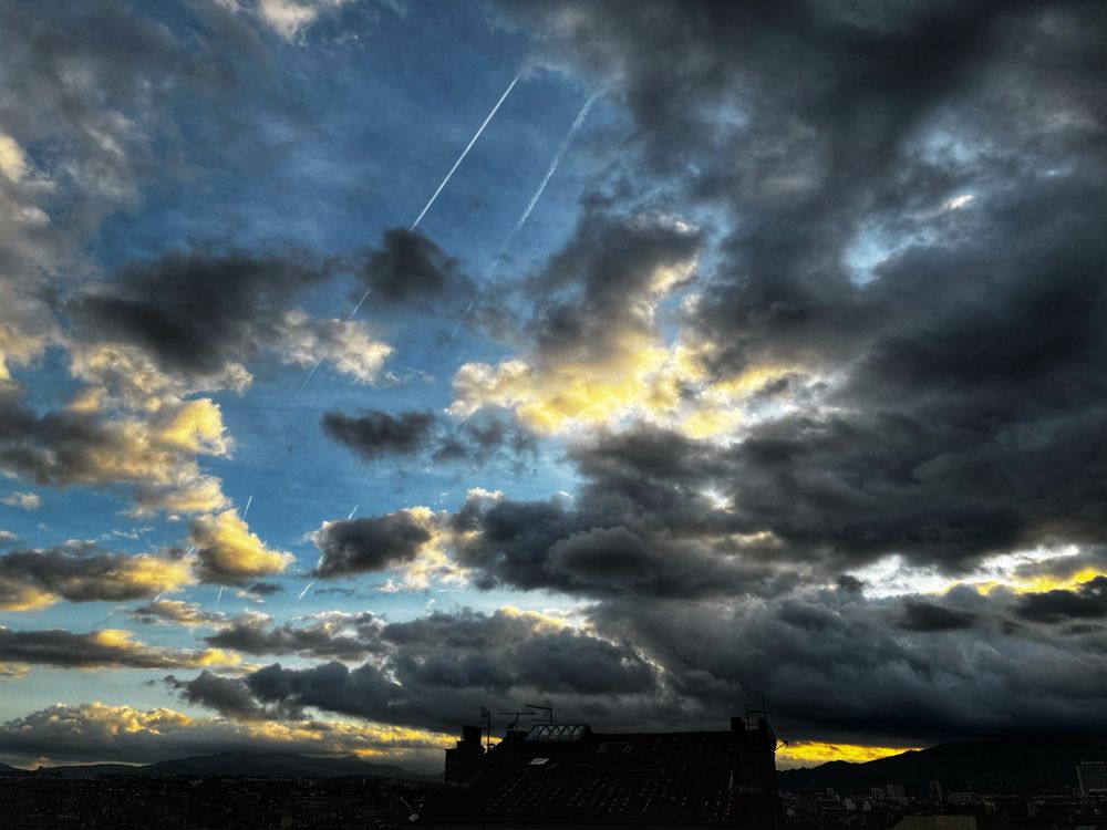 Early morning in my part of Marseille.

The boldness in the light is shining through the grey, angry clouds.  The backdrop to the clouds is the clear blue sky.