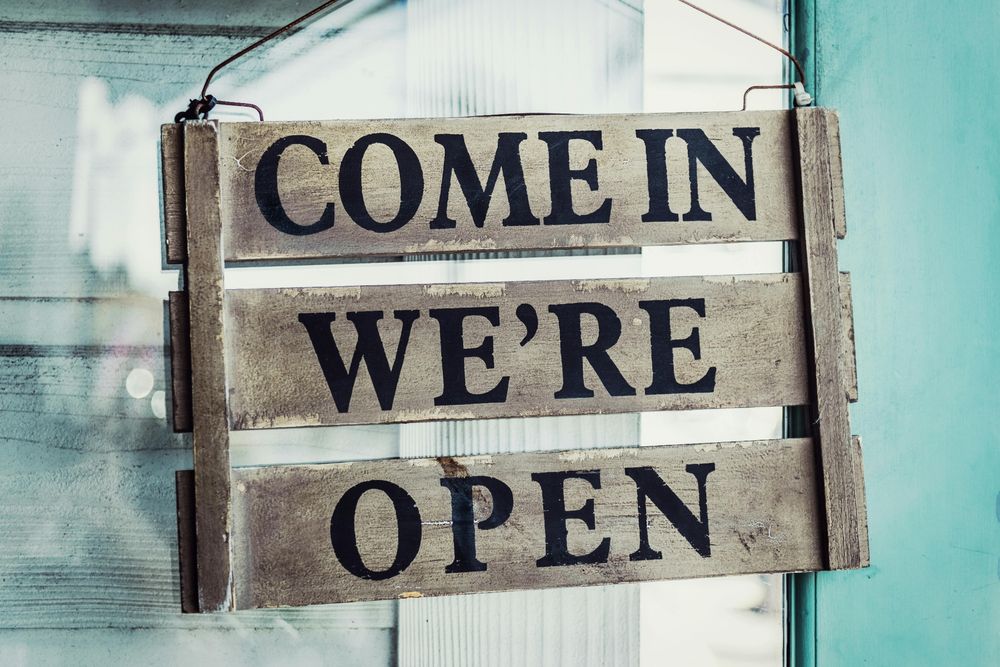 Photo by Tim Mossholder: https://www.pexels.com/photo/come-in-we-re-open-on-a-wooden-sign-hanging-on-a-door-4843912/