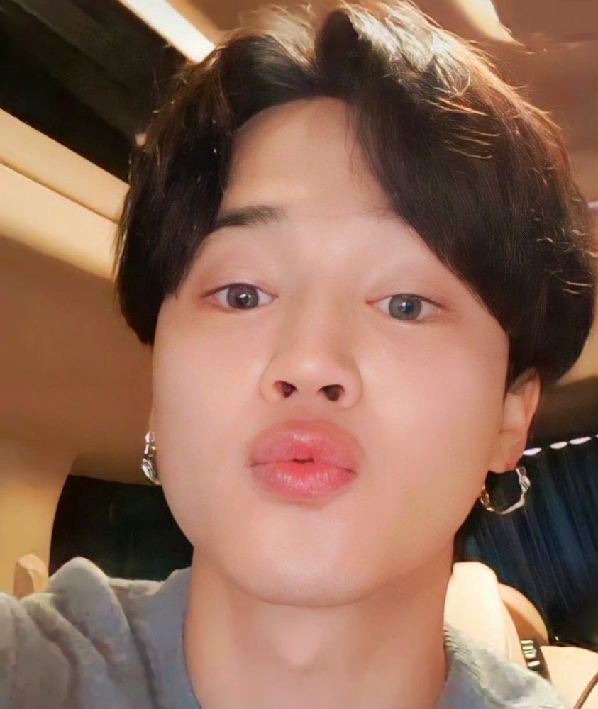 Screen shot from a live Jimin did in a car. It's a close up of his face, lips pursed as if he's blowing a kiss to ARMY (to me, but I guess yall can be included, too) and he has little silver hoops in his ears.