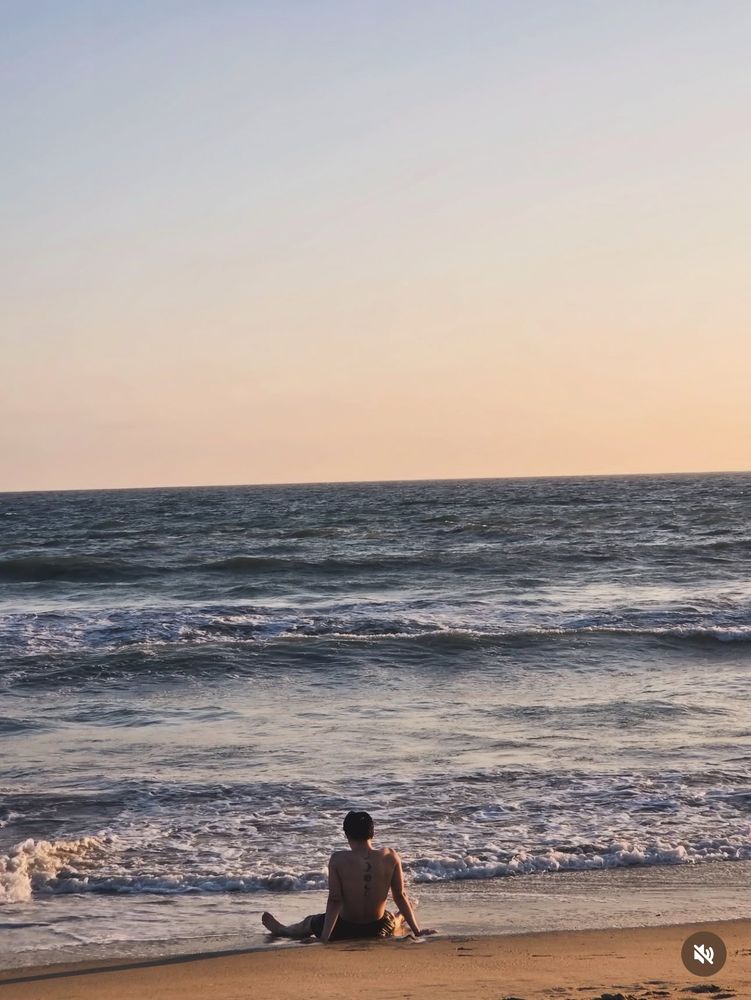 View of Jimin sitting on the beach facing the ocean. He’s shirtless and leaning back on his hands, little feetsies in the water. Each and every moon tattoo is on glorious display. 