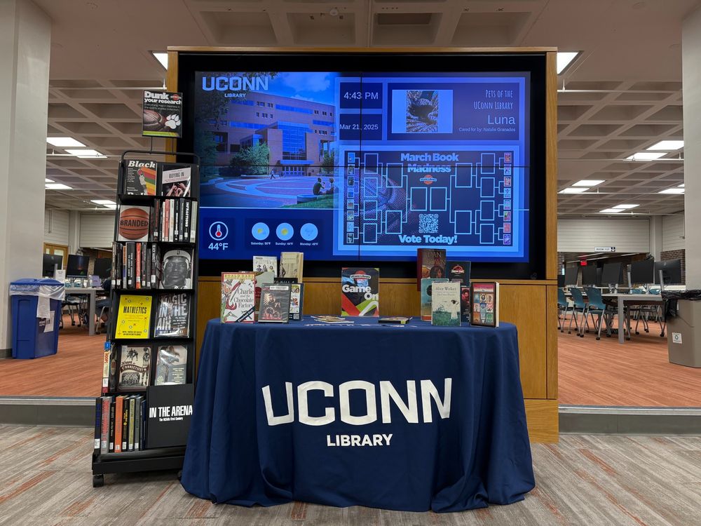Photo of Sports Studies collection and Books That Became Movies book display on Level 1 of Homer Babbidge Library. A March Madness Book Bracket is on a screen behind the book display.