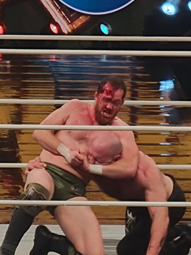 a bloody ass kyle o'reilly with moxley in a headlock