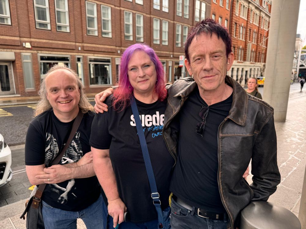 The author and her husband posing with Simon Gilbert, drummer for Suede.